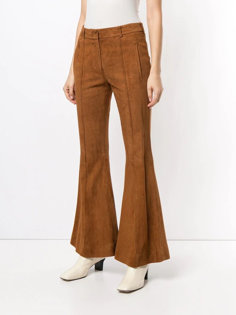 Pode incluir: Cal&ccedil;a de camur&ccedil;a marrom de boca de sino com cintura alta e corte reto. A cal&ccedil;a tem z&iacute;per e bot&atilde;o.