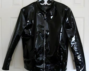Könnte beinhalten: Eine schwarze Lederjacke mit Reißverschluss. Die Jacke hat eine glänzende, glatte Oberfläche.