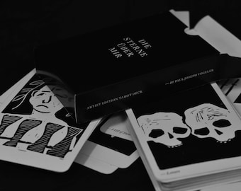 May include: A black box with white text that reads "Die Sterne Über Mir" and "Artist Edition Tarot Deck" with a card from the deck showing two black and white skulls.