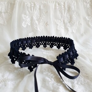 May include: A black crocheted lace choker with a satin ribbon tie. The choker is delicate and feminine, and would be a beautiful addition to any outfit.