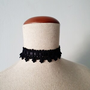 May include: A black lace choker with a delicate scalloped edge.