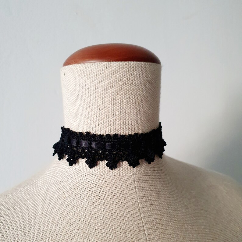 May include: A black lace choker with a delicate scalloped edge.