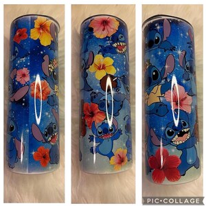 K&ouml;nnte beinhalten: Ein zylindrischer Becher mit blauem Hintergrund und einem sich wiederholenden Muster der blauen Figur Stitch sowie verschiedenen bunten Hibiskusbl&uuml;ten in Rot-, Orange-, Rosa- und Gelbt&ouml;nen, akzentuiert durch kleine wei&szlig;e sternartige Funken.