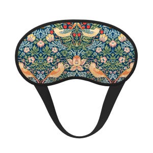 Könnte beinhalten: Schlafmaske mit schwarzem Riemen und floralem Muster. Die Maske hat einen dunkelblauen Hintergrund mit einem sich wiederholenden Design aus Vögeln, Blumen und Blättern in Orange-, Rosa- und Grüntönen.