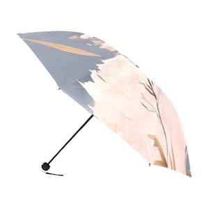 Puede incluir: Un paraguas plegable y compacto con un diseño floral en colores pastel suaves. El paraguas tiene un mango y una punta negros. La cubierta muestra una ilustración de flores y follaje al estilo acuarela sobre un fondo azul claro.