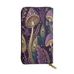Puede incluir: Una cartera con cremallera con un diseño caprichoso que presenta setas moradas, plumas de pavo real y follaje sobre un fondo morado oscuro. La cartera tiene un tirador de cremallera dorado y un borde negro.