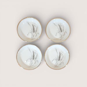 May include: A set of three ceramic mugs with a speckled, matte finish. The mugs are in shades of cream, light gray, and dark gray. Each mug has a simple, minimalist design, perfect for coffee or tea.