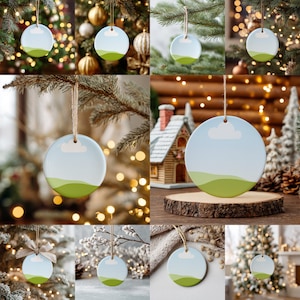 May include: A collection of round Christmas ornaments with a landscape design. Each ornament features a blue sky with a white cloud and green hills. They are hanging from twine and displayed on Christmas trees and festive backgrounds.