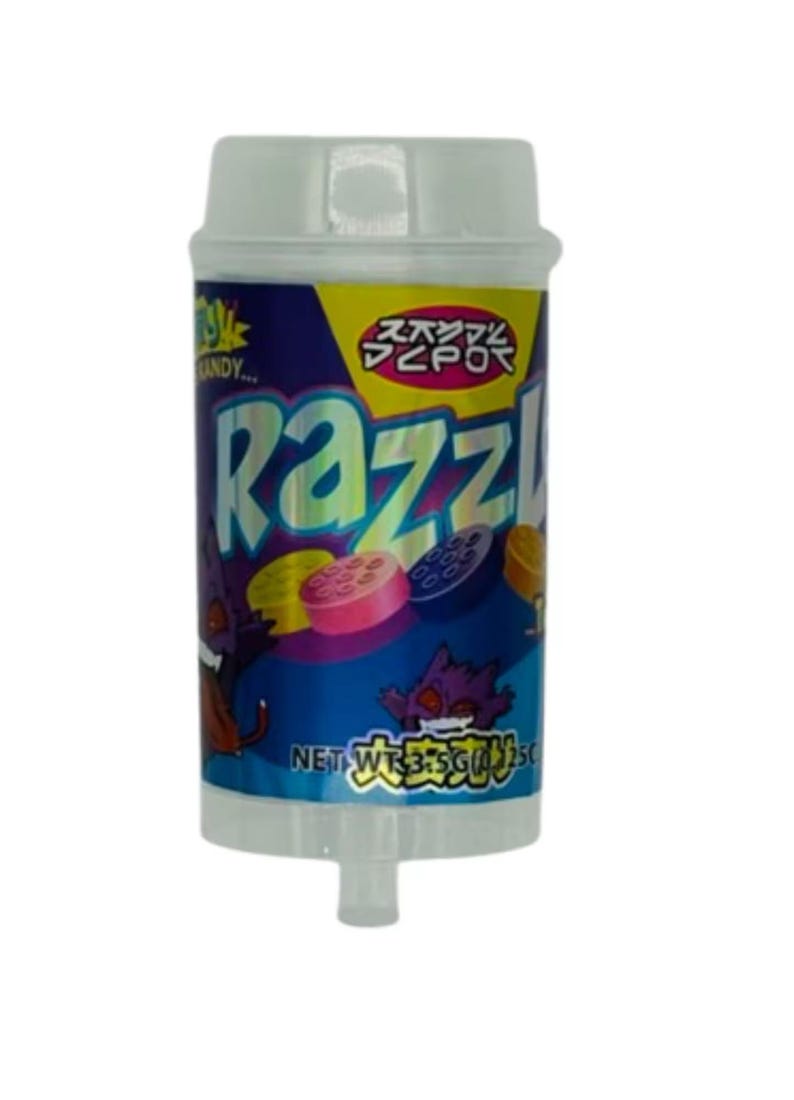 May include: A cylindrical candy container with a white cap and base. The label is blue with the word "Razzl" in large, colorful letters. The container features cartoon graphics and Japanese text. The net weight is 35g.