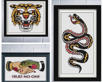 May include: Three framed cross-stitch embroidery designs. The first design is a tiger's head with orange, black, and white stripes. The second design is a black and red snake with yellow accents. The third design is a hand with a snake wrapped around it, with the text "TRUST NO ONE" below.