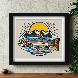 May include: Framed pixel art print featuring a colorful rainbow trout leaping from water, with a yellow sun and mountains in the background. The artwork is in a black frame, suitable for home or cabin decor.