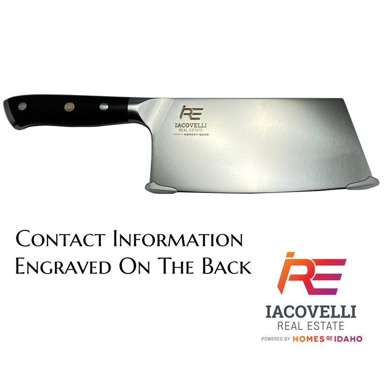 May include: A large, stainless steel cleaver with a black handle. The blade has a rectangular shape and features the logo "IACOVELLI REAL ESTATE" and the text "HOMES OF IDAHO".