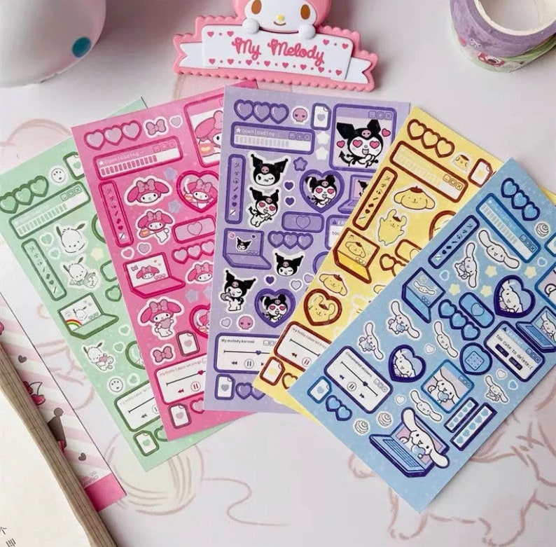 May include: Four sheets of colorful stickers featuring cartoon characters. The stickers are on a white background. The characters include a pink cat with a bow, a black cat with a crown, a yellow dog with a bow, and a white dog with a bow. The stickers are labeled "My Melody" and "Kuromi".