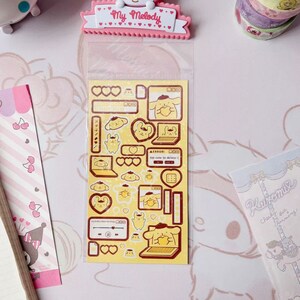 May include: A sheet of stickers featuring a yellow cartoon dog wearing a beret and holding a heart. The stickers are on a yellow background with red hearts and other details. The text on the stickers reads "ERROR! Too cute to delete!"
