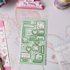 May include: A sheet of green and white stickers featuring a cartoon dog with a laptop. The stickers are in a clear plastic bag. The stickers have a computer theme with hearts, stars, and other computer icons.