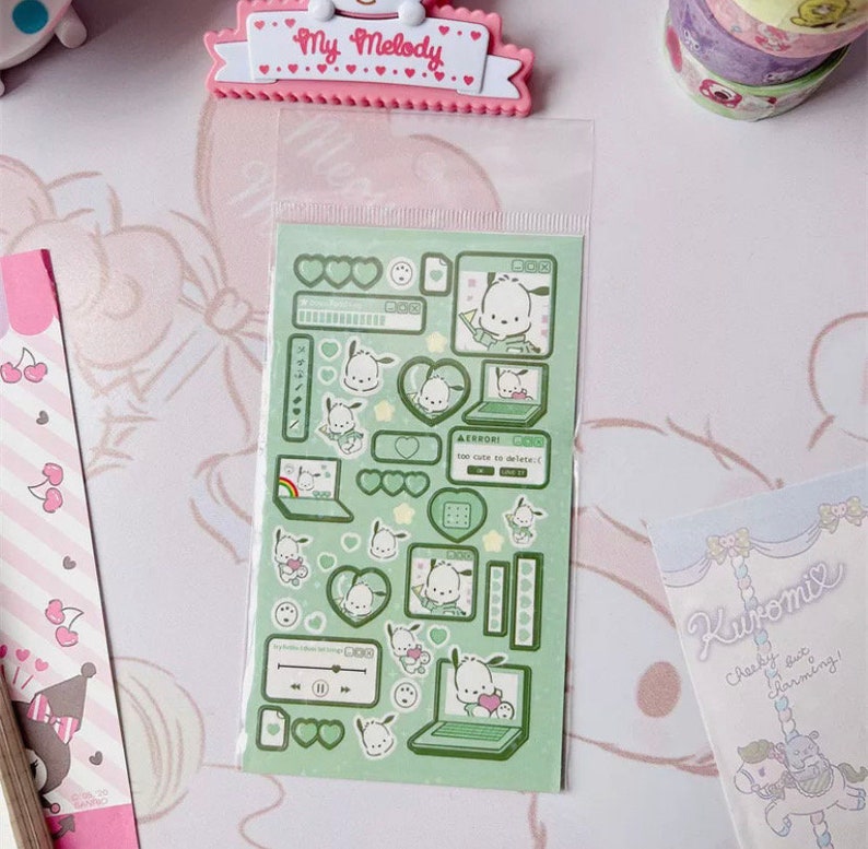 May include: A sheet of green and white stickers featuring a cartoon dog with a laptop. The stickers are in a clear plastic bag. The stickers have a computer theme with hearts, stars, and other computer icons.