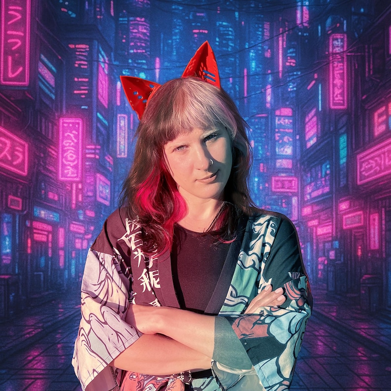 May include: A person wearing red cat ears, a black shirt, and a patterned kimono-style jacket. The background features a neon-lit cityscape with Japanese characters.