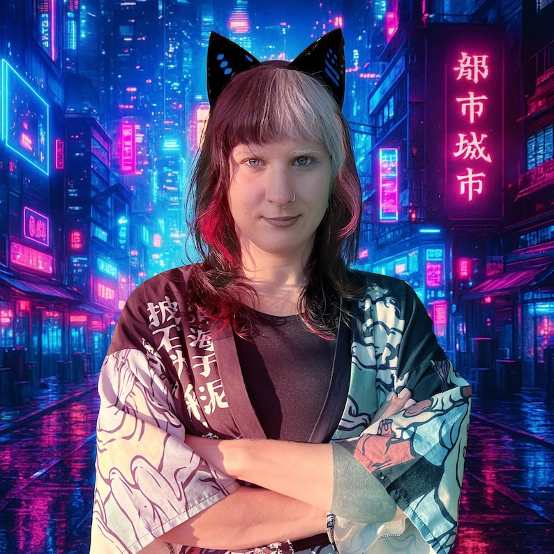 May include: A person wearing black cat ear headwear, a black shirt, and a patterned kimono-style jacket. The background features a neon-lit cityscape with Japanese characters.