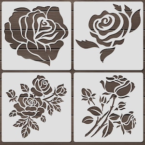 Może przedstawiać: Cztery białe szablony róż na tle ciemnego drewna. Każdy szablon przedstawia inny wzór róży, w tym otwarte kwiaty, pąki i liście. Idealne do rękodzieła i projektów dekoracyjnych.