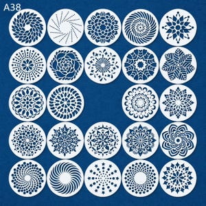 May include: A collection of twenty-four white, circular stencils with various intricate floral and geometric designs. The stencils are arranged in a grid pattern against a dark blue background. The top left corner has the text "A38".