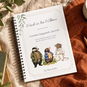 May include: A spiral-bound journal titled Wind in the Willows Cursive Copywork Journal by BloomsForBee. The white cover features a green willow branch illustration and three anthropomorphic animal characters in clothing, including a badger, mole, and rat.