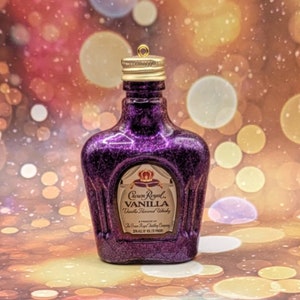 May include: A miniature purple glitter bottle with a gold cap and a gold label that reads 