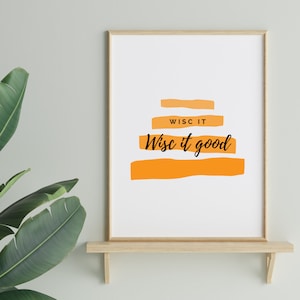 Könnte beinhalten: Gerahmter Kunstdruck mit dem Text "Wisc it good" in schwarzer Schrift über orangefarbenen horizontalen Balken. Der Druck wird auf einem Holzregal mit einer grünen Pflanze im Hintergrund angezeigt.