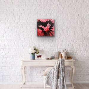 May include: Abstract painting with black and pink colors. The painting has a splatter effect and is framed in a white frame.