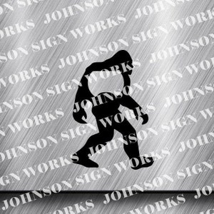 May include: A black silhouette of Bigfoot walking, with a detailed outline. The image is set against a brushed metal background with the text "JOHNSON SIGN WORKS" repeated diagonally. The overall design is simple and bold.