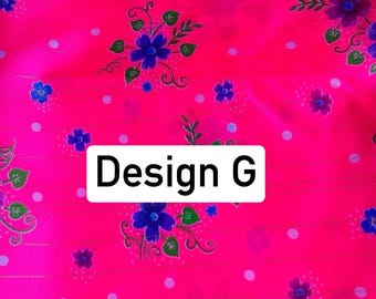 May include: Bright pink fabric with a floral pattern. The design features blue flowers, green leaves, and white polka dots. The text "Design G" is displayed in a white rectangle.
