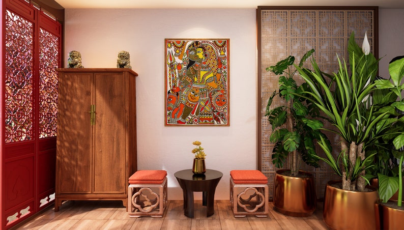 May include: A living room interior design with a wooden cabinet, two orange cushioned stools, a round black table, and two potted plants with gold pots. A framed painting with a colorful design hangs on the wall.