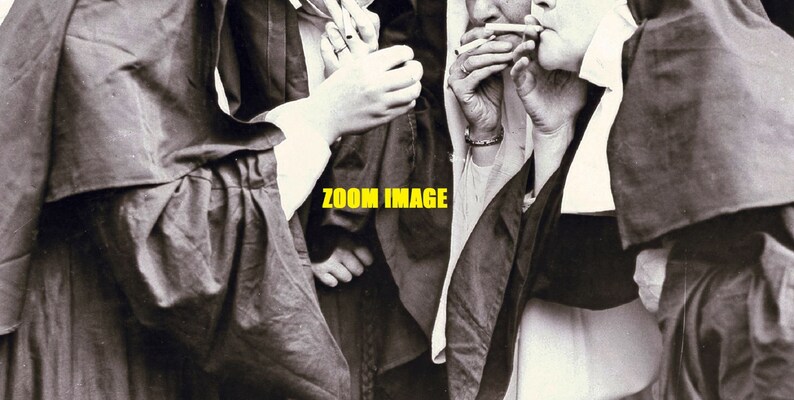 May include: A black and white photo of three people wearing long robes, two of whom are smoking cigarettes. The photo is captioned "ZOOM IMAGE".