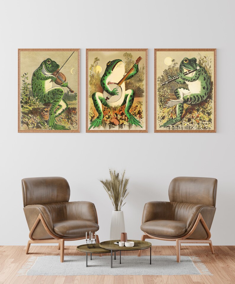 May include: Three framed illustrations of frogs playing musical instruments. The first frog plays a violin, the second plays a banjo, and the third plays a flute. The illustrations are in a vintage style with a green, brown, and yellow colour scheme.