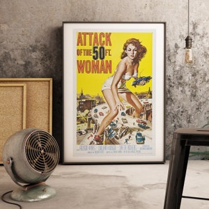 K&ouml;nnte beinhalten: Vintage Filmplakat f&uuml;r den Film "Attack of the 50 Ft. Woman". Das Plakat zeigt eine Frau in einem wei&szlig;en Bikini, die auf einer Autobahn steht und &uuml;ber Autos und Geb&auml;ude ragt. Das Plakat ist gelb mit schwarzem und rotem Text.