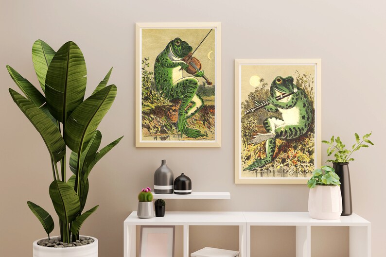 May include: Two framed illustrations of frogs playing musical instruments. The frog on the left is playing a violin and the frog on the right is playing a flute.