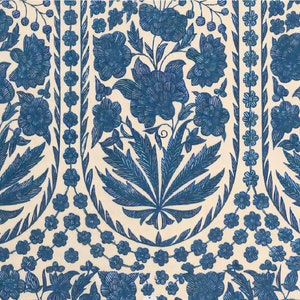 Puede incluir: Una tela blanca con un patr&oacute;n repetido de dise&ntilde;os florales azules. El patr&oacute;n presenta flores y hojas estilizadas.