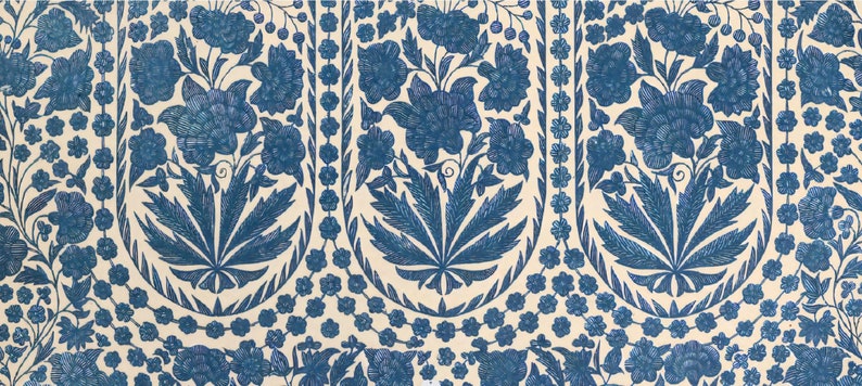 Puede incluir: Una tela blanca con un patr&oacute;n repetido de dise&ntilde;os florales azules. El patr&oacute;n presenta flores y hojas estilizadas.