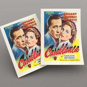 May include: Two prints of the movie poster for "Casablanca" featuring Humphrey Bogart and Ingrid Bergman. The poster has a blue background with red and yellow text. The film title is in large, stylized letters.