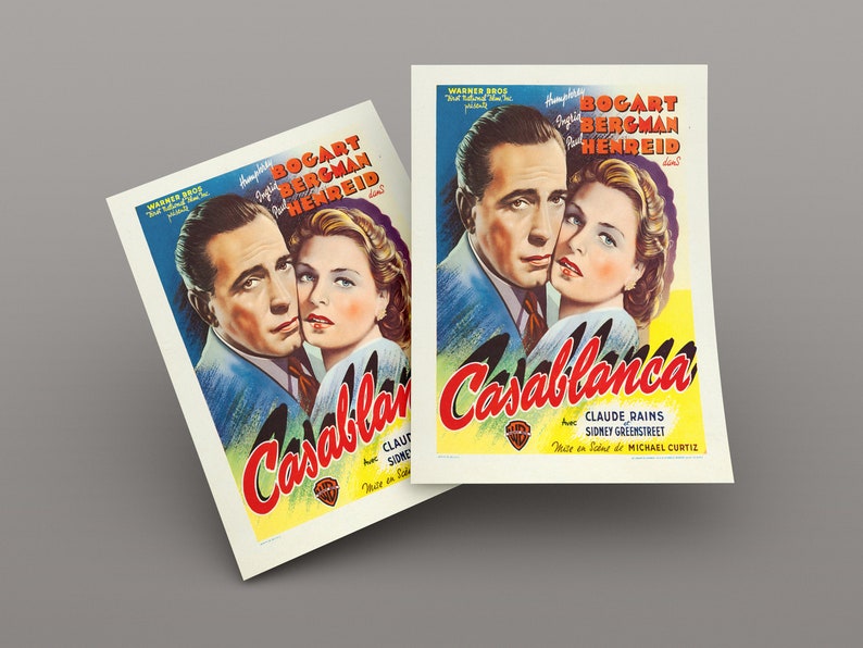 May include: Two prints of the movie poster for "Casablanca" featuring Humphrey Bogart and Ingrid Bergman. The poster has a blue background with red and yellow text. The film title is in large, stylized letters.