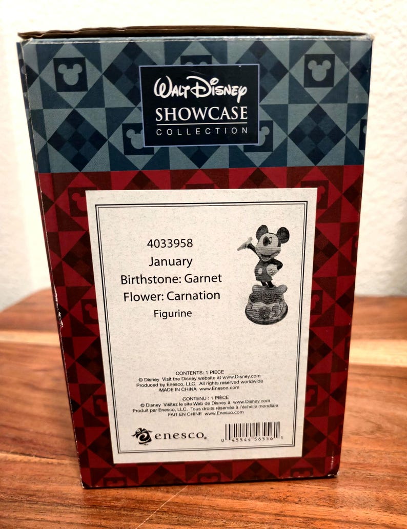 May include: A box from the Walt Disney Showcase Collection. The box is red and black with a Mickey Mouse figurine. The box has the text "January, Birthstone: Garnet, Flower: Carnation, Figurine."