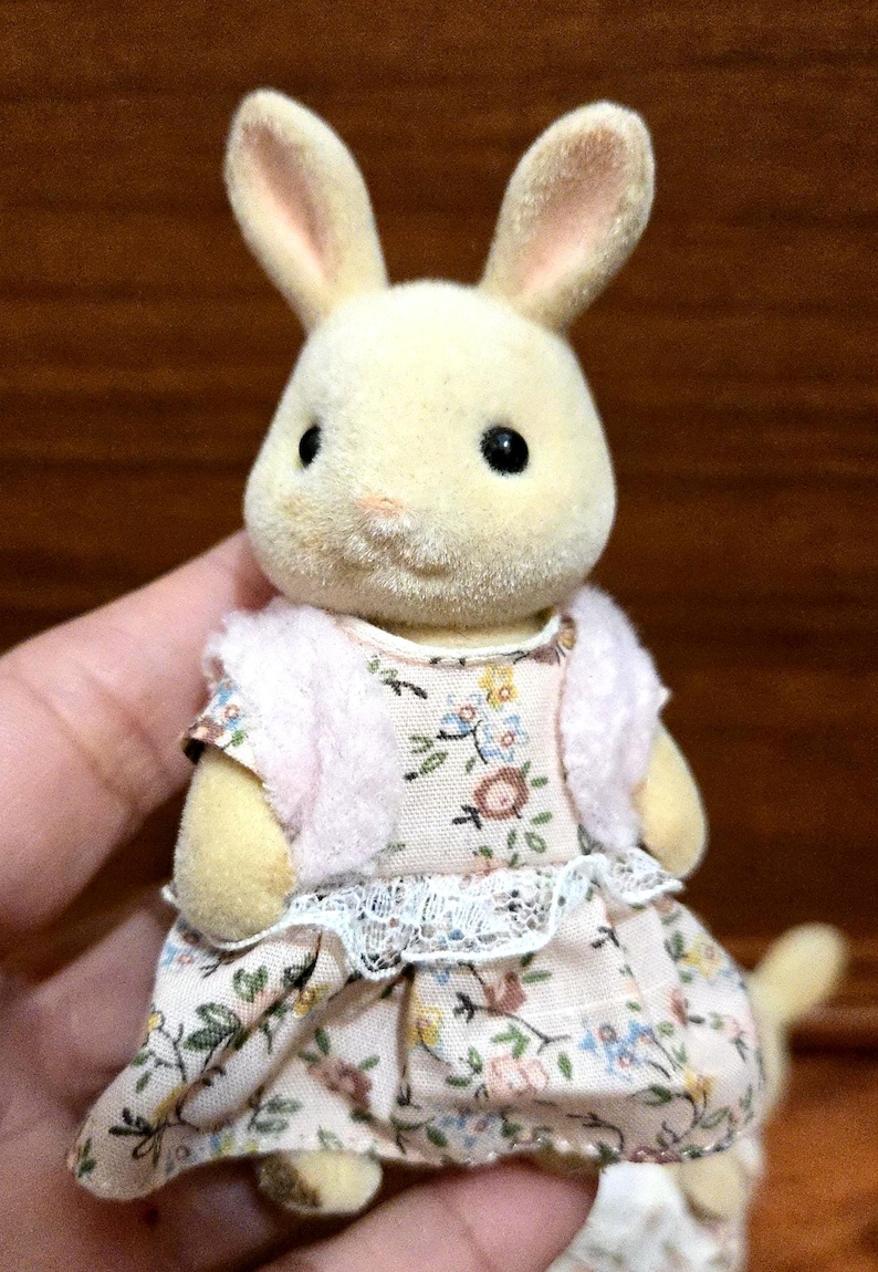 Op de afbeelding: Een set van drie keramische mokken met een gespikkelde, cr&egrave;mekleurige glazuur. Elke mok heeft een ander handgeschilderd ontwerp: een blauw en groen blad, een gele bloem en een rode bes. De mokken hebben een eenvoudige, afgeronde vorm.