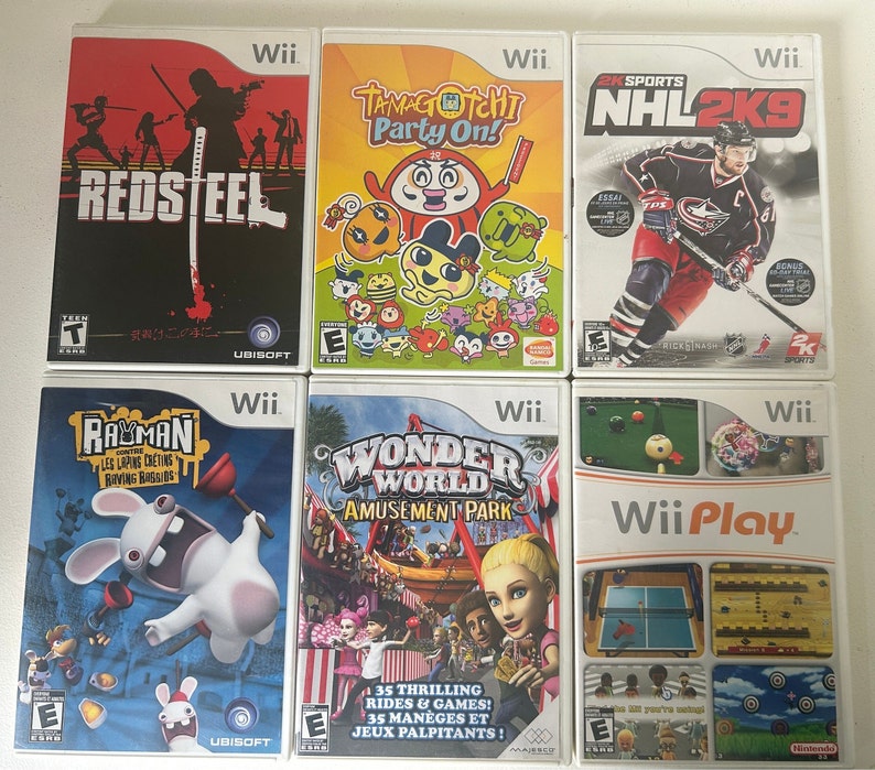 K&ouml;nnte beinhalten: Sechs Wii-Videospielh&uuml;llen werden gezeigt. Zu den Titeln geh&ouml;ren "Red Steel", "Tamagotchi Party On!", "NHL 2K9", "Rayman Raving Rabbids", "Wonder World Amusement Park" und "Wii Play". Die H&uuml;llen zeigen farbenfrohe Grafiken und spielspezifische Kunstwerke.