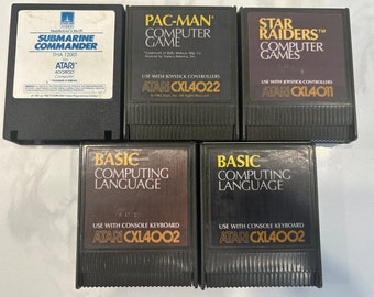 Puede incluir: Cinco cartuchos de juego Atari para la computadora Atari 400/800. Los cartuchos son negros con letras doradas e incluyen títulos como "Submarine Commander", "Pac-Man", "Star Raiders" y "Basic Computing Language".