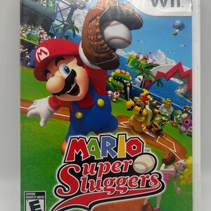 K&ouml;nnte beinhalten: Wii-Spielh&uuml;lle f&uuml;r Mario Super Sluggers. Das Cover zeigt Mario in einem Baseballhandschuh, der einen Baseball f&auml;ngt. Andere Charaktere befinden sich im Hintergrund auf einem Baseballfeld. Das Spiel ist f&uuml;r alle ab 6 Jahren freigegeben.