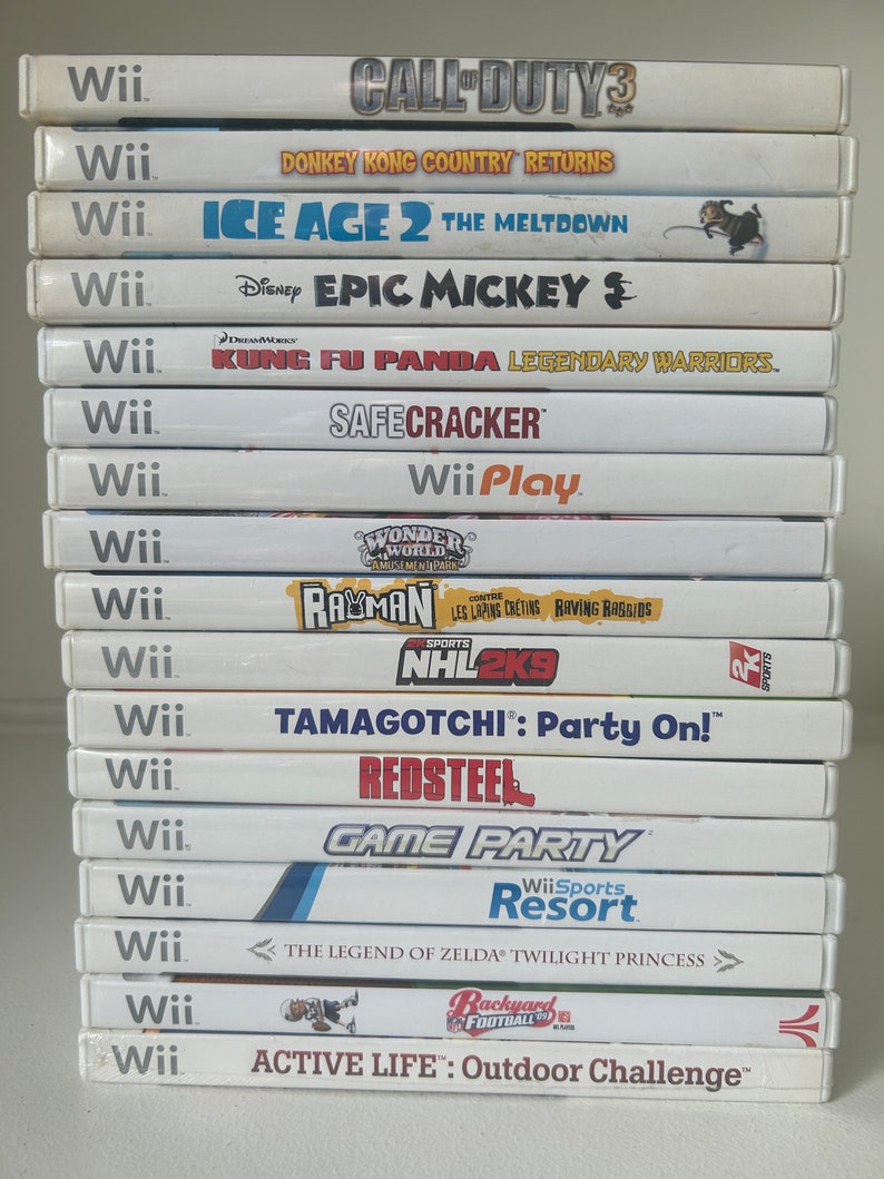 K&ouml;nnte beinhalten: Ein Stapel von Wii-Spielh&uuml;llen. Titel sind u.a. "Call of Duty 3", "Donkey Kong Country Returns", "Ice Age 2: The Meltdown", "Epic Mickey", "Kung Fu Panda", "SafeCracker", "Wii Play", "Rayman", "NHL 2K9", "Tamagotchi", "Red Steel", "Game Party", "Wii Sports Resort", "The Legend of Zelda" und "Active Life".