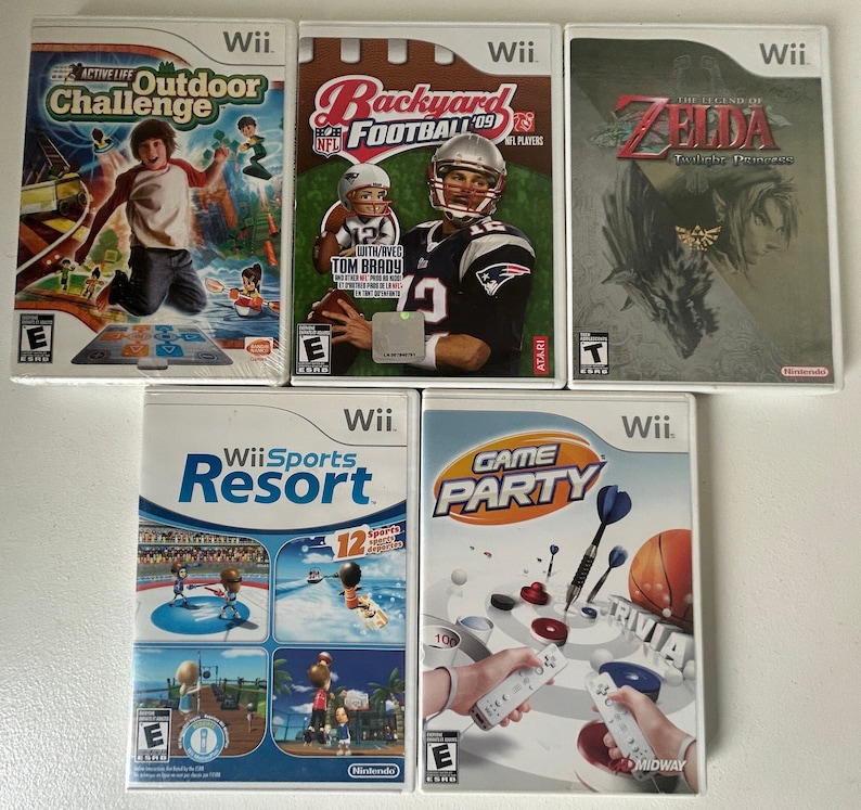 K&ouml;nnte beinhalten: F&uuml;nf Wii-Spielh&uuml;llen werden gezeigt. Zu den Titeln geh&ouml;ren "Active Life: Outdoor Challenge", "Backyard Football '09", "The Legend of Zelda: Twilight Princess", "Wii Sports Resort" und "Game Party". Die H&uuml;llen zeigen farbenfrohe Grafiken und spielbezogene Bilder.