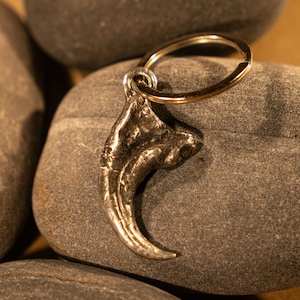 Hand sculpted and cast Velociraptor dinosaur claw as a keychain or large pendant in lead free antiqued pewter.
