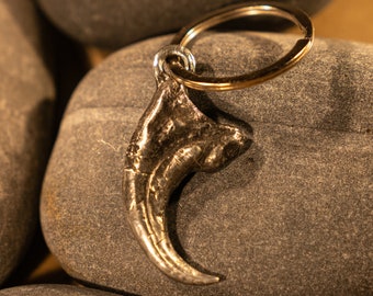 Hand sculpted and cast Velociraptor dinosaur claw as a keychain or large pendant in lead free antiqued pewter.