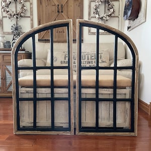 May include: A pair of arched wooden windowpane wall decor with black painted frames. The windows are made of glass and have a rustic, farmhouse style.