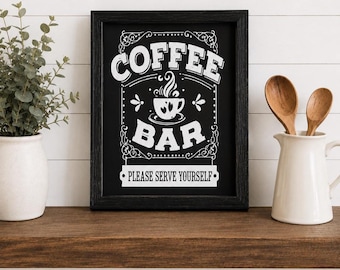 May include: A black framed sign with white text that reads COFFEE BAR and PLEASE SERVE YOURSELF, featuring a graphic of a steaming coffee cup. The sign is positioned between a green plant in a white vase and a white pitcher containing two wooden spoons.